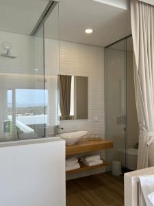 bagno con lavandino e specchio di Alojamento White Rose Boutique a Zambujeira do Mar