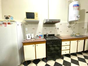 a kitchen with a stove and a refrigerator at Casa de Beto in San Pedro
