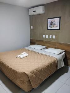 1 dormitorio con 1 cama grande y toallas. en Pousada Boi Bumbá Praia, en João Pessoa