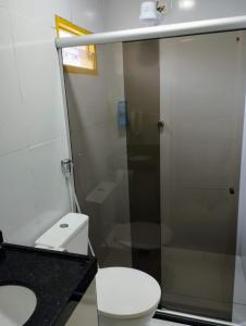 a bathroom with a toilet and a glass shower at Pousada Boi Bumbá Praia in João Pessoa