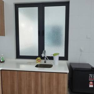 a kitchen counter with a sink and a window at 1 bed room service apartment for 3 guests in Petaling Jaya