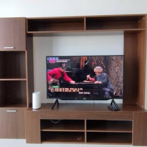 TV de pantalla plana en un centro de entretenimiento de madera en 1 bed room service apartment for 3 guests en Petaling Jaya