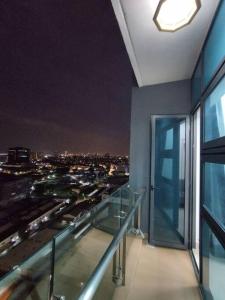 a balcony with a view of a city at night at 1 bed room service apartment for 3 guests in Petaling Jaya