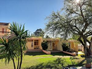 a house with a palm tree in the yard at Complejo Mirador de las Sierras pileta climatizada al aire libre in San Javier