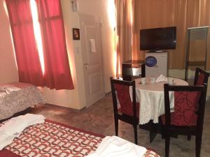 a room with a table and chairs and a television at Complejo Mirador de las Sierras pileta climatizada al aire libre in San Javier +28 photos