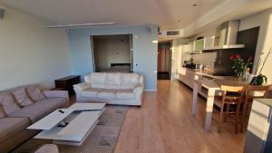 a living room with white furniture and a kitchen at Pirita Beach View Suites in Tallinn