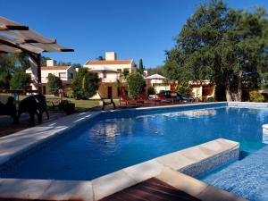 a swimming pool with blue water in a yard at Complejo Mirador de las Sierras pileta climatizada al aire libre in San Javier