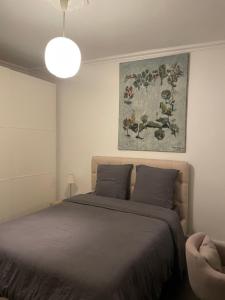 1 dormitorio con 1 cama y una pintura en la pared en MAISON STANDING PROCHE ROLAND GARROS et JO 2024 en Boulogne-Billancourt
