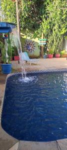 a water fountain in a yard with a bench at POUSADA MAORI Boiçucanga in Boicucanga