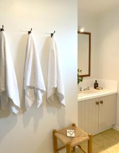 a bathroom with white towels hanging on a wall at The Ridge in Burnt Pine