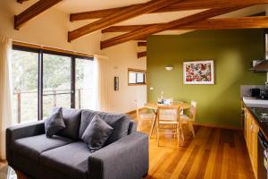 Freycinet Resort في كولز باي: غرفة معيشة مع أريكة وطاولة