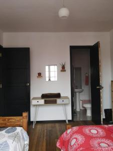a bedroom with a bed and a desk and a bathroom at Hostal Vitalia in Santiago