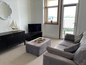 a living room with a couch and a tv at A Shore Stay in Gourock