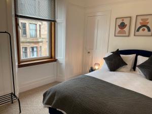 a bedroom with a bed and a window at A Shore Stay in Gourock