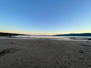 a sandy beach with the ocean in the background at A Shore Stay in Gourock