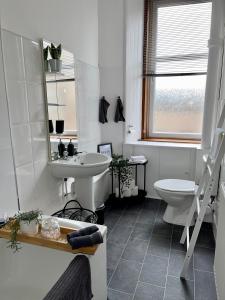 La salle de bains blanche est pourvue d'un lavabo et de toilettes. dans l'établissement A Shore Stay, à Gourock