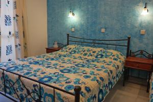 a bedroom with a bed with a blue and white comforter at Katerina Babis Studios in Agios Prokopios