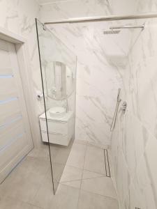 a white bathroom with a shower and a toilet at Apartamenty Morze u Sary in Dziwnówek