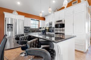 a kitchen with white cabinets and black bar stools at Long Island Village 502 Clam in Port Isabel