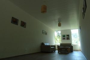 sala de estar con sofá y silla en Refúgio Melissa, en Campos do Jordão