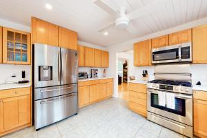 a kitchen with wooden cabinets and stainless steel appliances at Sunlit Serenity in West Tisbury