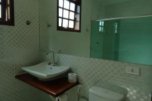 Un baño con lavabo, inodoro y espejo. en Refúgio Melissa, en Campos do Jordão 66 fotos más