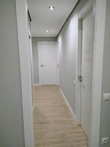 a hallway with white walls and a wooden floor at GRAN FAMILIA in Santander