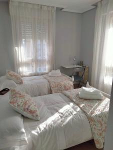a bedroom with two beds and a desk at GRAN FAMILIA in Santander