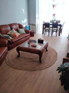 a living room with a leather couch and a coffee table at GRAN FAMILIA in Santander