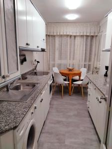 a kitchen with a sink and a table with chairs at GRAN FAMILIA in Santander