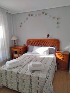 a bedroom with a large bed with two towels on it at GRAN FAMILIA in Santander