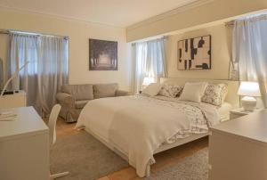 a white bedroom with a bed and a couch at Harmony Apartment Close to Dowtown Center Mall in Bella Vista in Santo Domingo