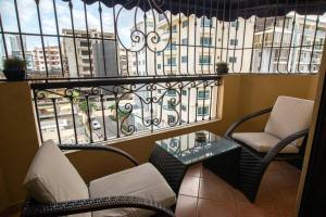 a balcony with chairs and a table and a window at Harmony Apartment Close to Dowtown Center Mall in Bella Vista in Santo Domingo