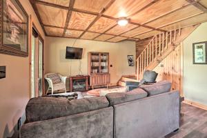 a living room with a couch and a staircase at Quiet Adirondack Cabin on Private Lake! in Glenfield