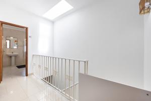 Biały korytarz ze schodami i łazienką w obiekcie Green Diamond Budens w mieście Budens