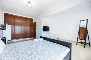 a bedroom with a large bed and a tv at Green Diamond Budens in Budens