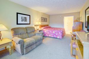uma sala de estar com um sofá e uma cama em Mountain Aire Inn Sevierville - Pigeon Forge em Sevierville
