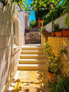 una escalera con una puerta y algunas plantas en Apartments Jakšić en Supetar