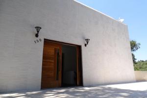 a white building with a door and lights on it at Refúgio Melissa in Campos do Jordão