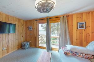 ein Schlafzimmer mit Holzwänden und einem großen Fenster in der Unterkunft Island House in Hancock