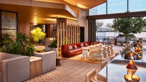 a hotel lobby with a couch and tables at Conrad Los Angeles in Los Angeles