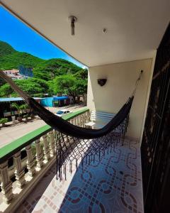 a hammock on a balcony with a view of a street at Rodadero Confort Mar y Sol in Rodadero