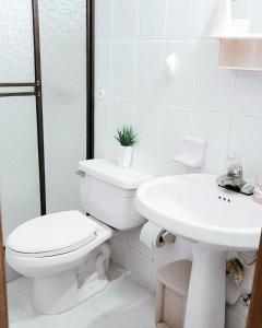 Baño blanco con aseo y lavamanos en Rodadero Confort Mar y Sol, en Rodadero
