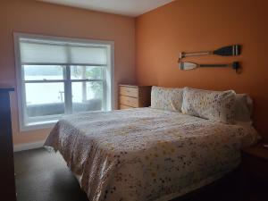 1 dormitorio con cama y ventana en Crescent Lakehouse - Surf, Ski and Serenity, en Iron River