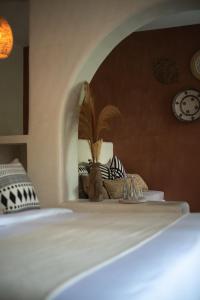 a bedroom with a bed with a plant on it at White Goose Boutique Hotel in Canggu