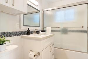 a white bathroom with a sink and a shower at Mission Point 1 by AvantStay San Diego Beach House w Huge Patio Fire Pit Walk to Beach in San Diego