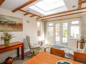 a living room with a skylight at Holly Cottage in Swaffham