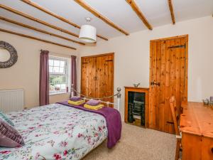 a bedroom with a bed and a fireplace at Holly Cottage in Swaffham
