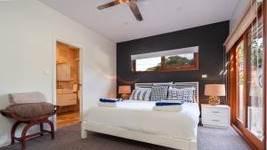 a bedroom with a white bed and a chair at Tula in Currarong