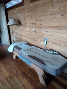 Bett in einem Zimmer mit einer Holzwand in der Unterkunft Octogono Om Shanti in Villa Serrana